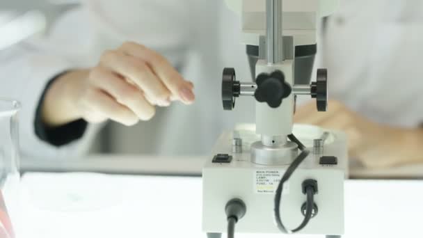 4k Nahaufnahme medizinischer Forscher, die im Labor arbeiten und ins Mikroskop schauen - Filmmaterial, Video