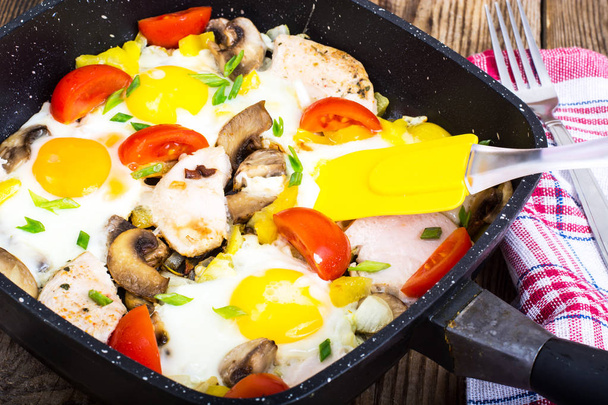 Fried eggs, tomatoes, ham, mushrooms in frying pan - Photo, Image
