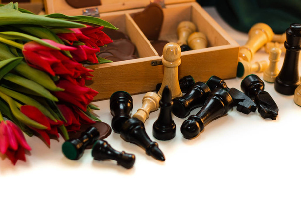 Strauß roter Tulpen, Schokoladenherzen und Schach - Foto, Bild