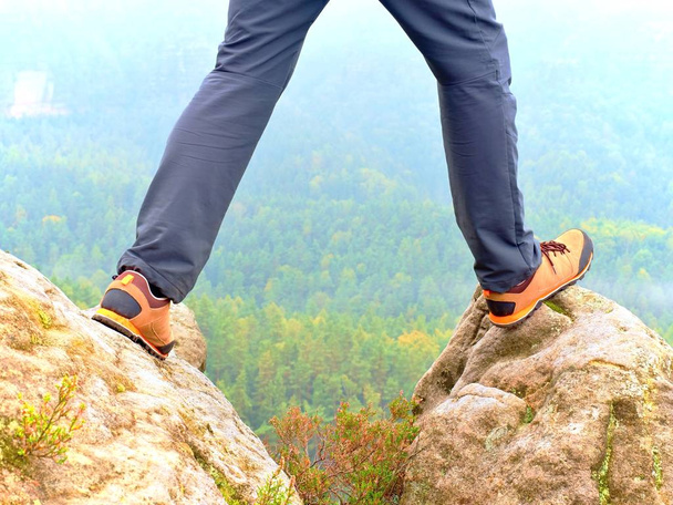 Pernas de caminhante em confortáveis botas de trekking na rocha. Homem pernas em calças leves ao ar livre, sapatos de couro
 - Foto, Imagem