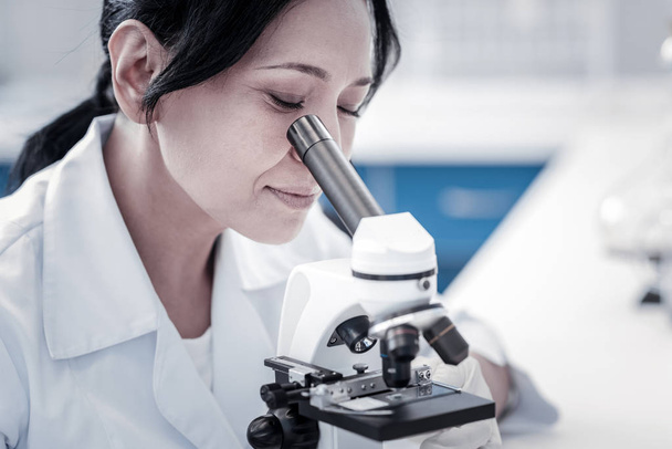 Charming mature lady examining sample under microscope - Foto, Imagem