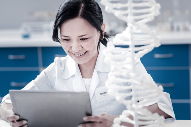 Cheerful genetic scientist using tablet computer in lab - Photo, image