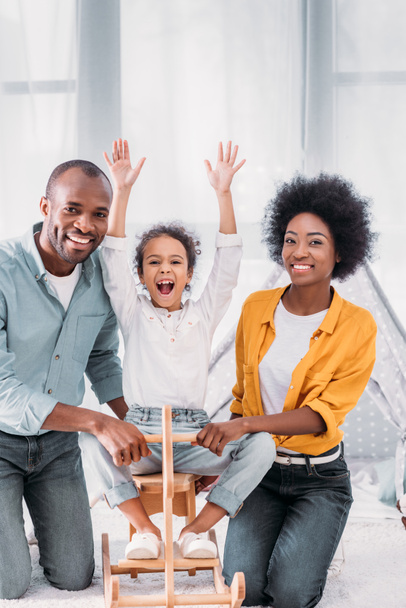 アフリカ系アメリカ人の両親とロッキング ホース自宅で遊ぶ娘 - 写真・画像