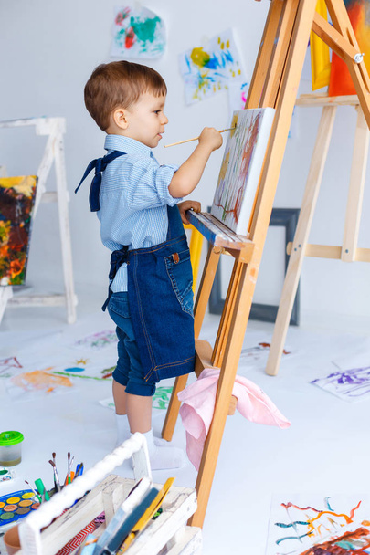 Carino, serio e concentrato, bianco ragazzo di tre anni in shi blu
 - Foto, immagini