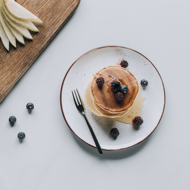 top view of tasty healthy pancakes with berries on grey - Фото, зображення