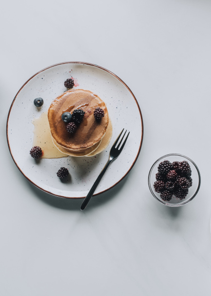 top view of tasty homemade pancakes and fresh healthy berries on grey - Photo, Image