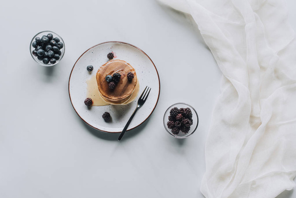 top view of tasty homemade pancakes with honey and fresh berries on grey  - Φωτογραφία, εικόνα