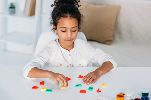 adorable african american kid learning colored numbers at home - Foto, Imagen