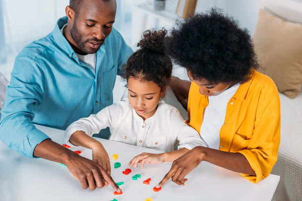 pais afro-americanos ensinando matemática filha em casa
 - Foto, Imagem