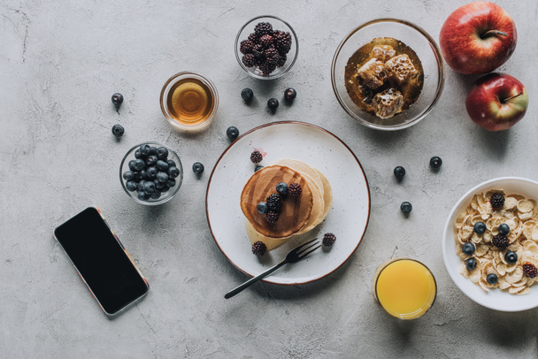 вид сверху на смартфон с чистым экраном и вкусный здоровый завтрак на сером
 - Фото, изображение