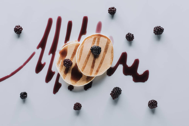 top view of delicious pancakes with fresh blackberries and jam on grey    - Fotó, kép