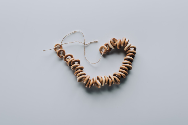 vista superior de bagels saborosos doces na corda isolada no cinza
 - Foto, Imagem