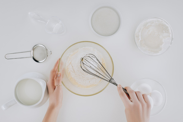 cropped shot of person whisking dough while cooking pancakes isolated on grey - Zdjęcie, obraz