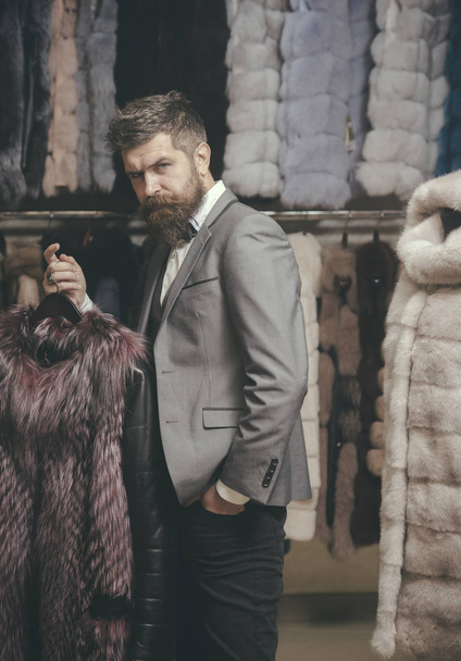 Man with beard and mustache hold fur coat. - Zdjęcie, obraz