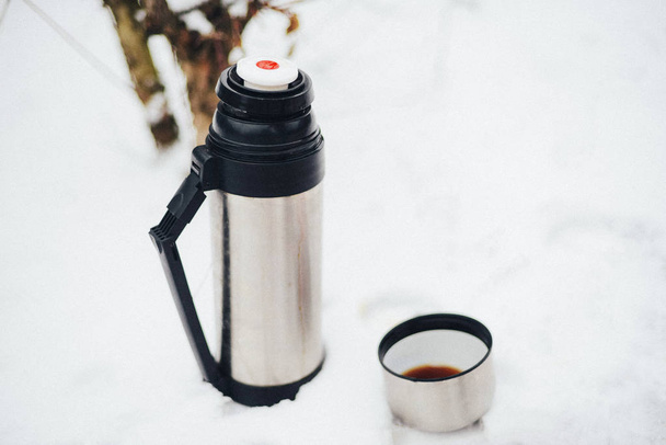ręce kobieta wylewa gorącej herbaty lub kawy z termosem na zimowe dla - Zdjęcie, obraz