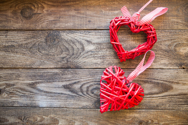 red wicker heart with ribbon on a wooden background - Fotoğraf, Görsel
