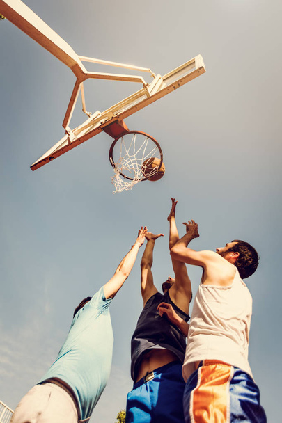 4 つのバスケット ボール選手には、屋外のトレーニングがあります。遊んでいて路地 oop のためにジャンプ. - 写真・画像