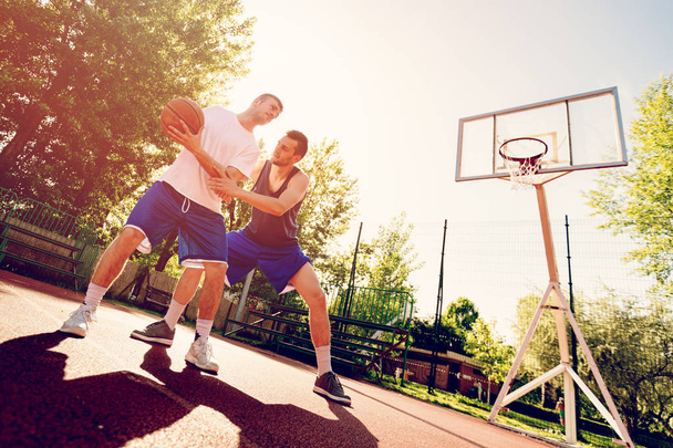 Due giocatori di basket di strada che si allenano all'aperto. Stanno facendo una buona azione
. - Foto, immagini