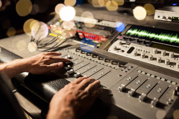 man using mixing console in music recording studio - Foto, afbeelding