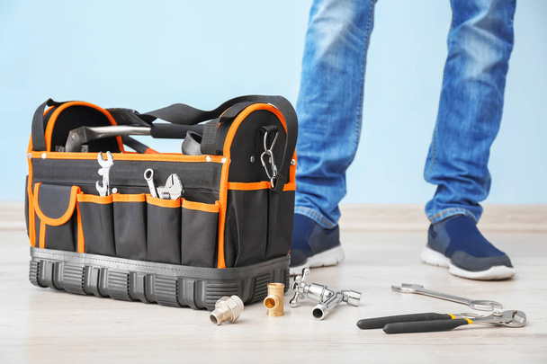 Jeune plombier debout près du sac à outils, gros plan
 - Photo, image