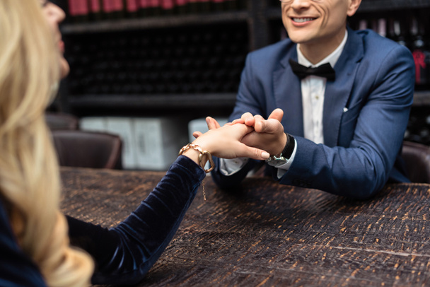 cropped shot of couple having date at restaurant and holding hands - Fotoğraf, Görsel