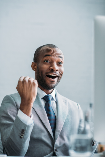 portrait of excited african american businessman at workplace in office  - Foto, Bild