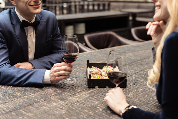 cropped shot of happy adult couple drinking wine at restaurant - Foto, imagen