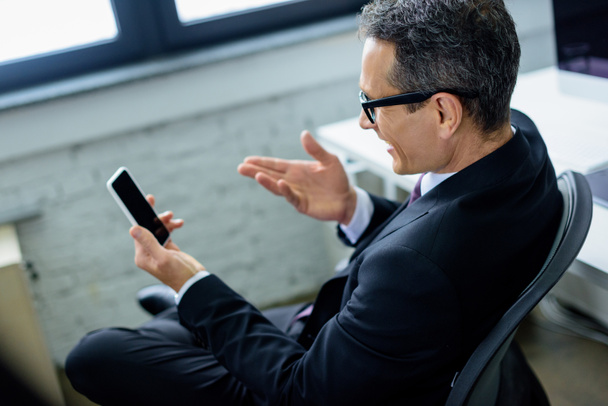 side view of smiling businessman using smartphone - Photo, image