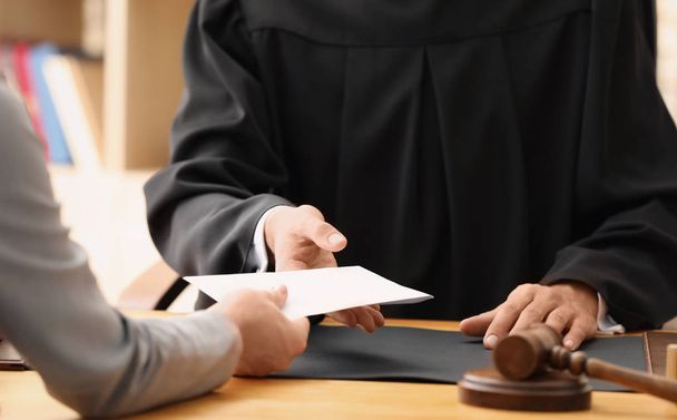 Male judge taking bribe from woman, closeup - Foto, imagen