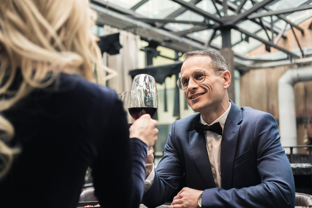 happy adult couple clinking glasses of wine at restaurant - Zdjęcie, obraz
