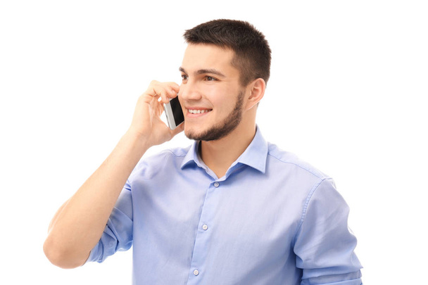 Young man talking on cell phone against white background - Valokuva, kuva