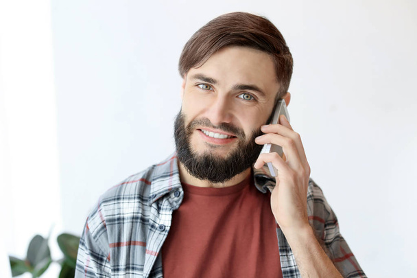 Handsome man talking on cell phone indoors - Fotoğraf, Görsel