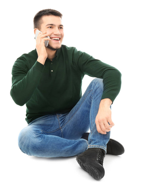 Young man talking on cell phone against white background - Photo, Image