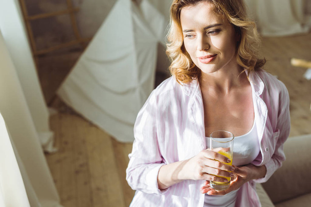 attractive woman in pajamas with orange juice in the morning - Fotó, kép