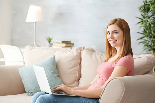 Beautiful smiling woman using laptop at home - Foto, Bild