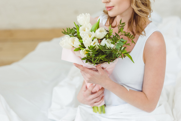 cropped view of woman with bouquet of flowers for international womens day - Fotó, kép