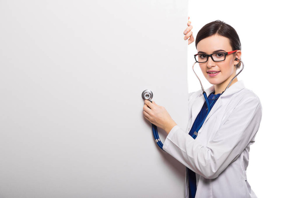 Young female doctor with stethoscope and blank card  - Foto, Bild