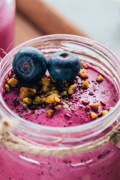 close-up view of sweet healthy smoothie with granola, nuts and blueberries - Фото, зображення