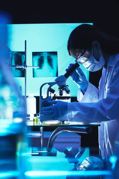 Professional female microbiologist using microscope in laboratory - Photo, Image