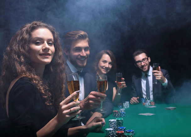 grupo de amigos sentados en la mesa de juego en el casino
 - Foto, imagen