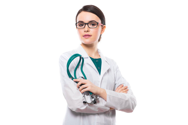 Young female doctor with stethoscope holding stethoscope in hand and looking at camera  - Fotoğraf, Görsel