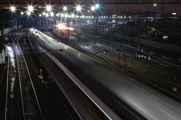 The train rushes on the rails at night. - Φωτογραφία, εικόνα