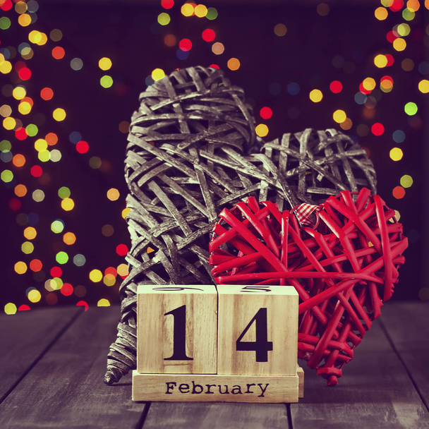 Two wooden hearts and a calendar with a date on February 14 on a dark table. Valentines Day. Copy space - Photo, Image