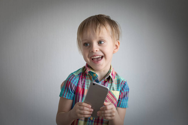 little boy with a smartphone in his hands. childs portrait - Фото, изображение