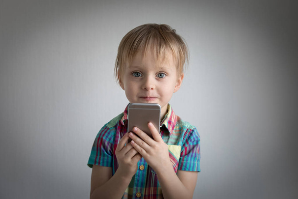 a kis fiú a kezében egy smartphone. Childs portré - Fotó, kép