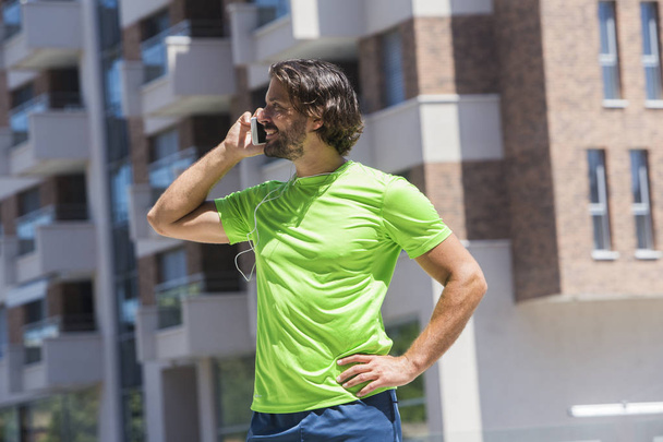 Retrato de corredor masculino usando telefone celular ao ar livre
 - Foto, Imagem