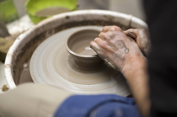 Gros plan détail vue chez un artiste fait poterie d'argile sur une roue de rotation
 - Photo, image