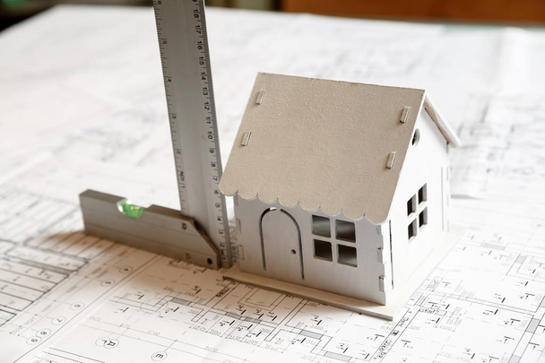 Model of a house on top of blueprints and architect tools - Photo, Image