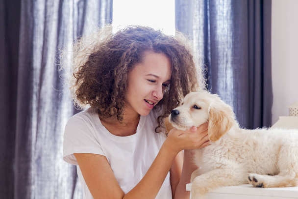Teenager girl with a small golden retriever - Foto, afbeelding