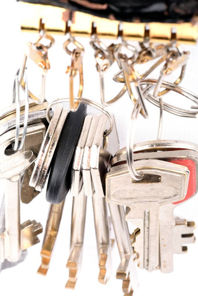 Mnoho objektů - kovových klíčů viset připojené kruhů na bílém podkladu - Fotografie, Obrázek